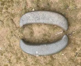 Piedra de moler tallada en forma de media luna sobre la tierra (línea de tiempo, Chontalito).