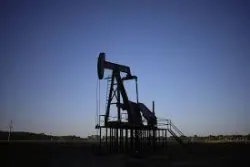 Silueta de un balancín de extracción de petróleo al atardecer (línea de tiempo, empresas extractivas).