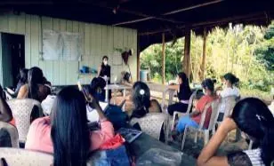 Personas, sobre todo mujeres jóvenes, sentadas en un salón durante un taller (línea de tiempo).