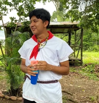 Joven con cusma blanca, pañuelo rojo y chumbe sosteniendo un vaso (vestido del hombre).