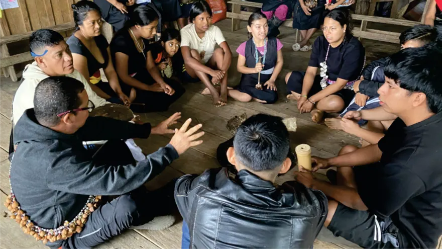 Jóvenes y adultos sentados en círculo en el piso (registro fotográfico).