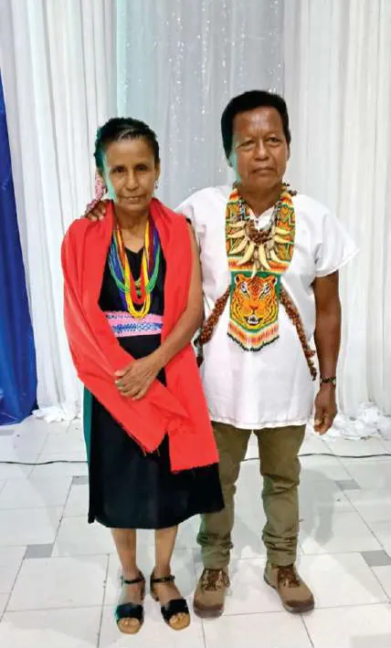 Médicos tradicionales: una mujer con chal rojo y un hombre con collar de colmillos y pectoral con figura de tigre.