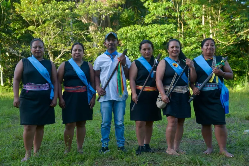 Seis personas de la comunidad de pie en un potrero (variante de la foto de p2).