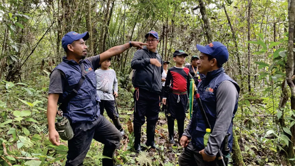 Integrantes de la guardia indígena (Wuasikamas) con chaleco, en el bosque.