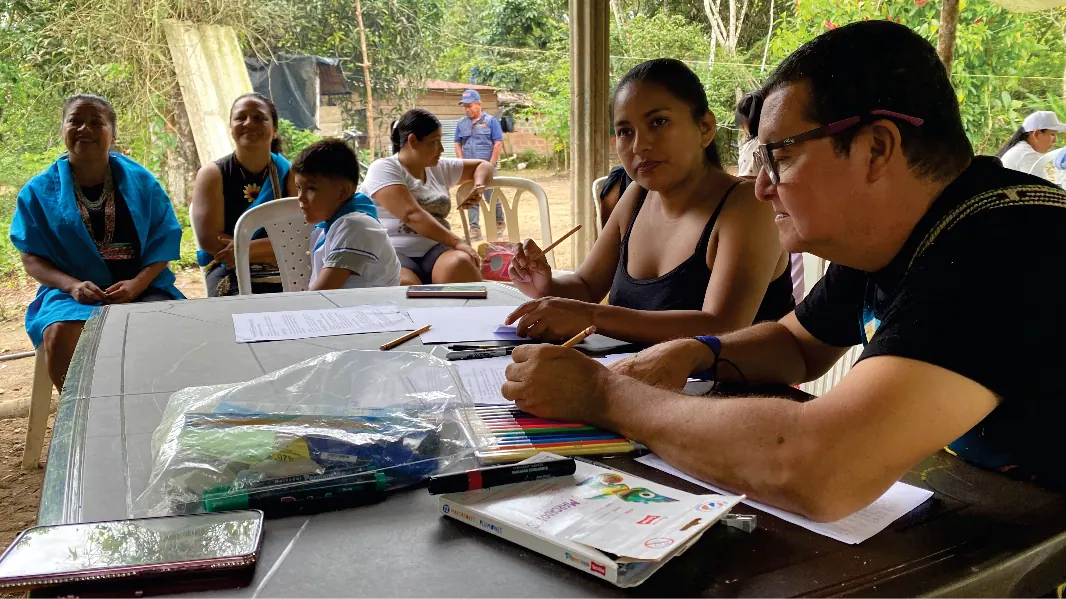 Personas trabajando con documentos sobre una mesa (registro fotográfico).
