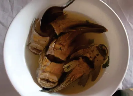 Plato blanco con pescado en caldo.