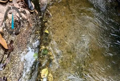 Agua corriendo sobre roca, con marca de geolocalización.