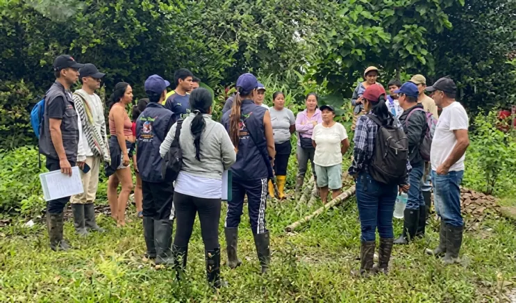 Grupo de personas de pie en un potrero durante un recorrido.