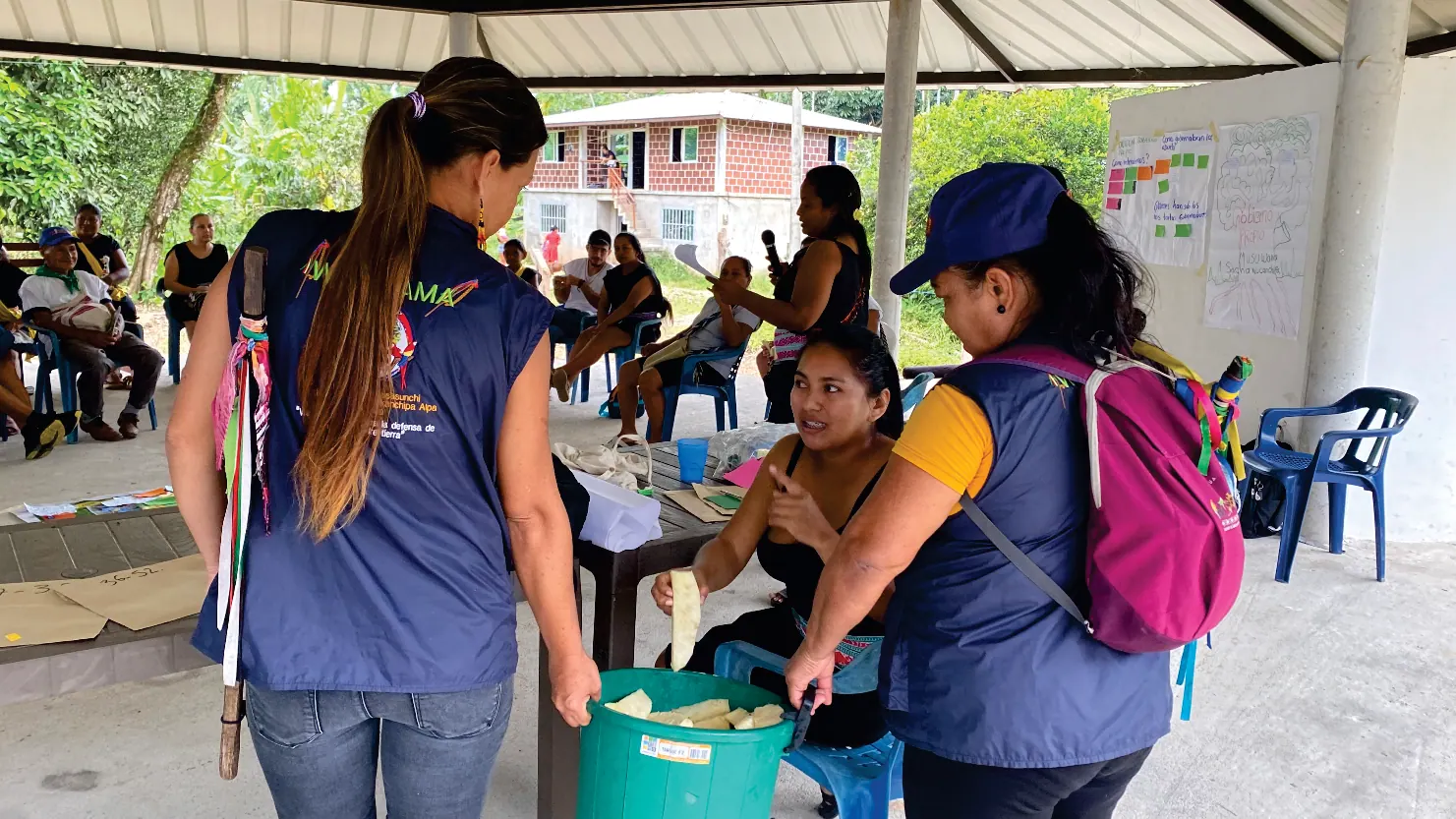 Wasikamas con chalecos y gorras en una reunión bajo techo.