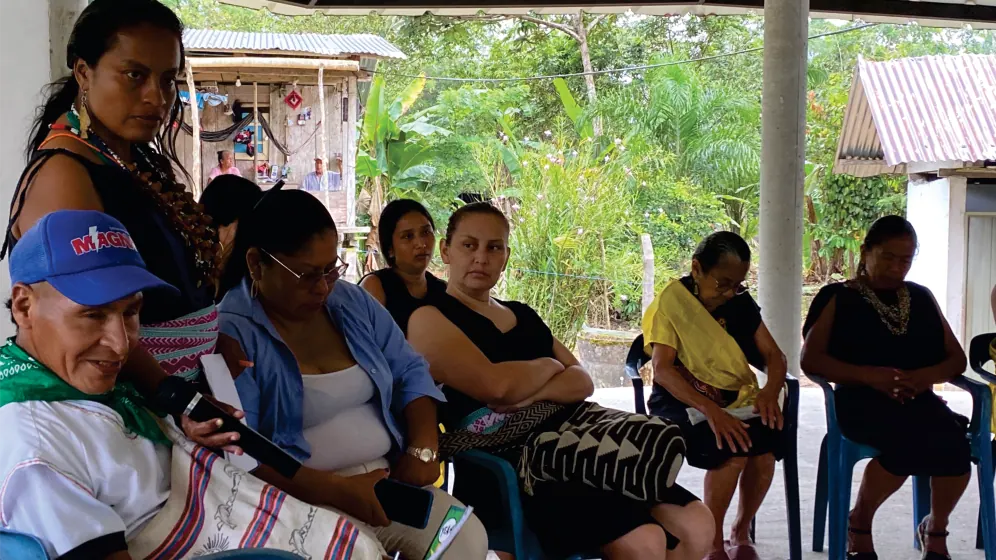 Mujeres sentadas en una reunión bajo techo.