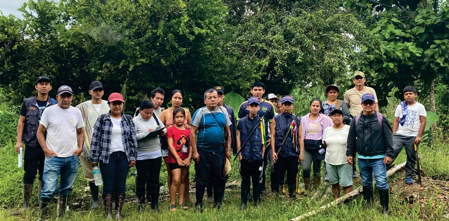 Grupo grande de personas de pie en un potrero.