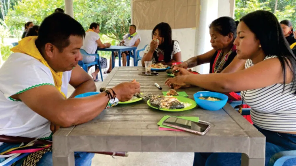 Personas compartiendo alimentos en una mesa.