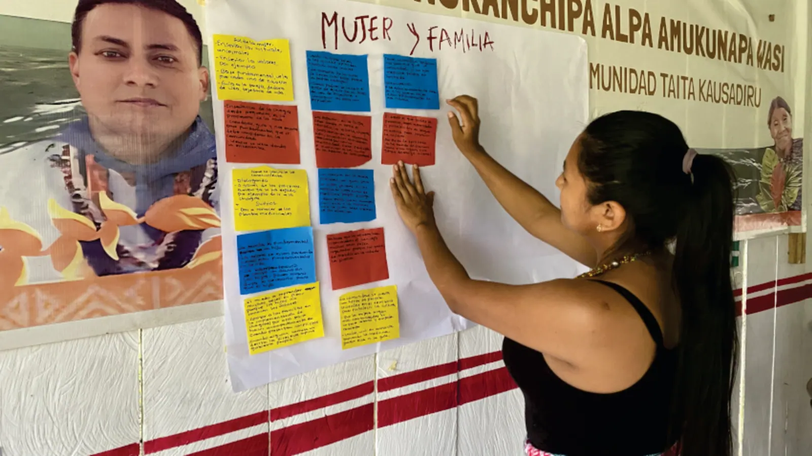 Mujer frente a una cartelera de «Mujer y Familia» con notas de colores.