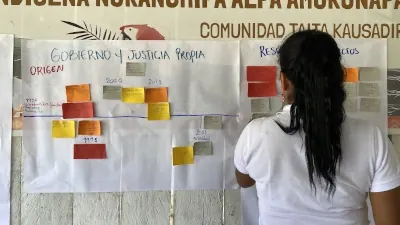 Mujer frente a una cartelera de «Gobierno y Justicia Propia».