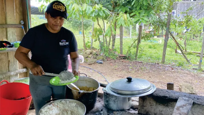 Hombre cocinando en un fogón al aire libre.